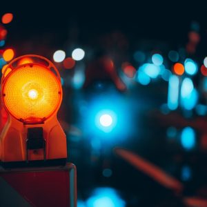 A closeup shot of a warning lamp in the street at night